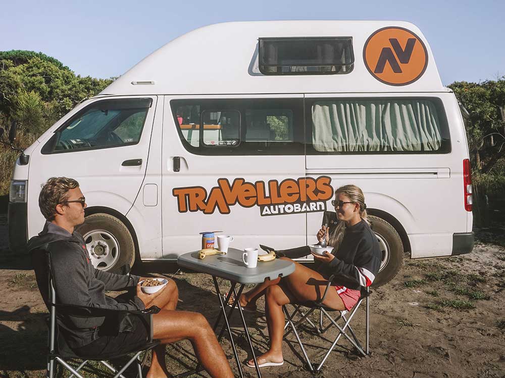 Travellers Autobarn customers eating their breakfast at the beach.