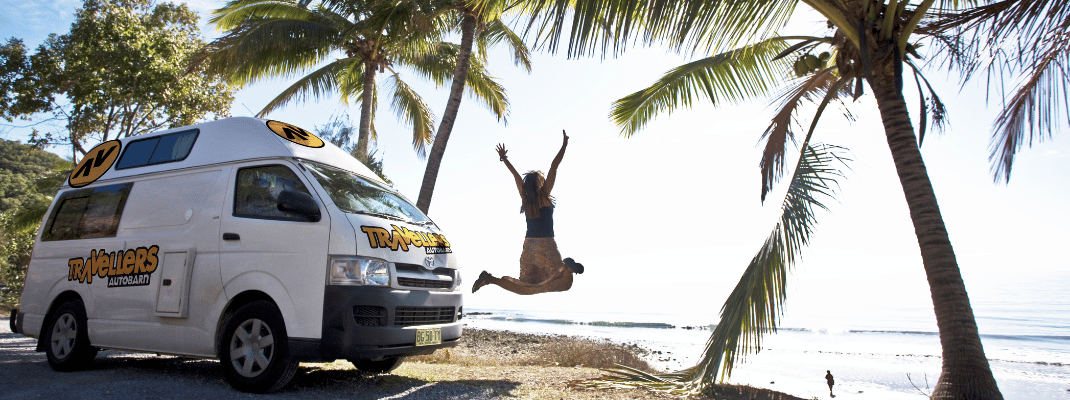 Person jumping next to campervan in Palm Cove, Queensland