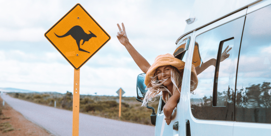 Campervan on road in Australia next to kangaroo sign